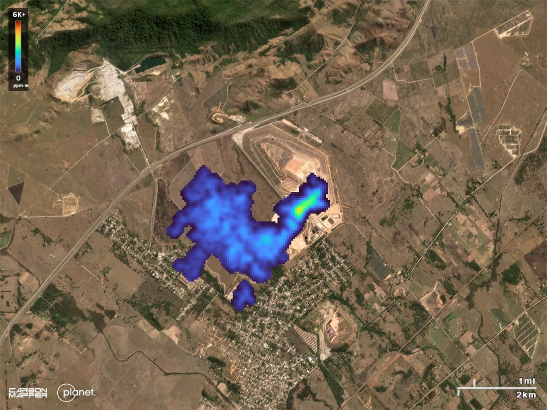 On the background of a satellite image, a methane plumes can be seen at a landfill in Brazil. The plume is colored with a gradient that matches the methane emissions intensity of its emissions.